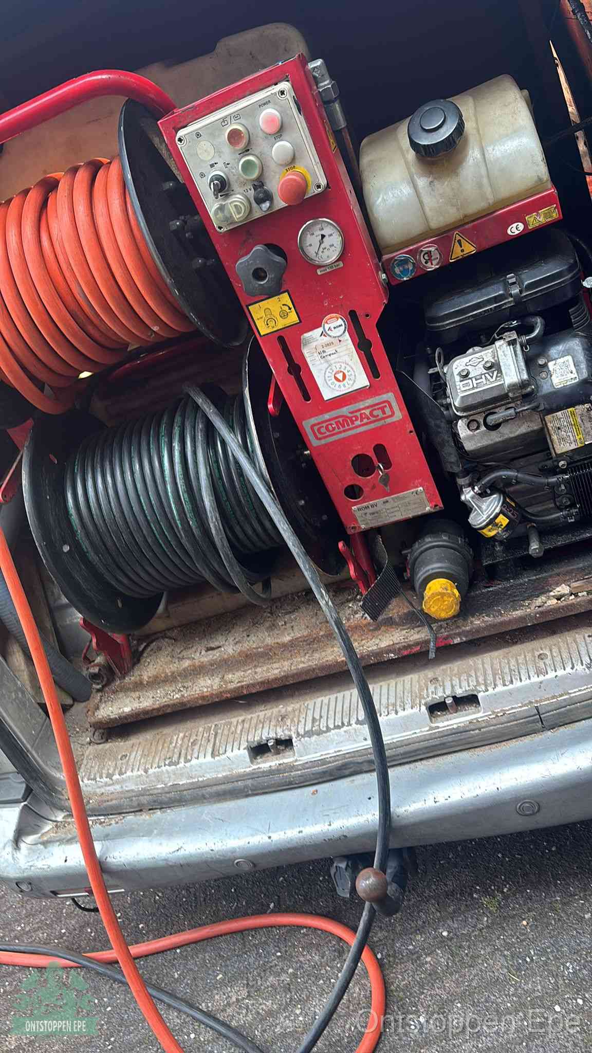 Een rood hogedruk-rioolreinigingstoestel met slangen in de laadbak van de bedrijfsbus, apparatuur voor een hardnekkige wc-verstopping in Epe