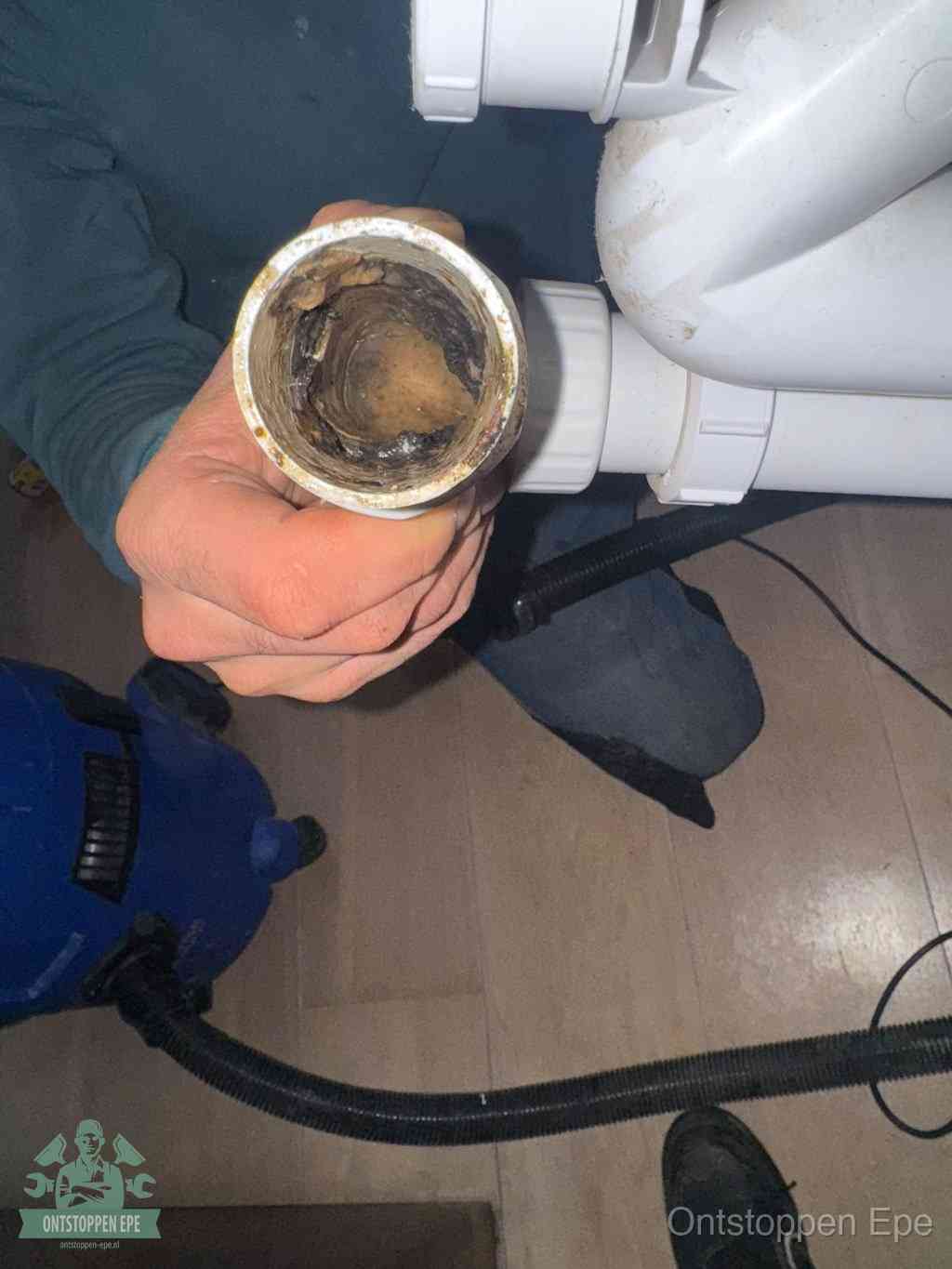 Een losgekoppelde afvoerbuis die van binnen volledig is dichtgeslibd met vet en aanslag, de meest voorkomende oorzaak van een verstopte gootsteen in Epe