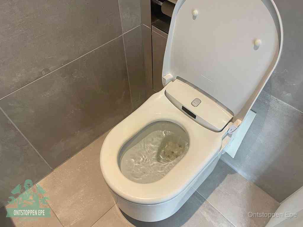 Een toiletpot vol troebel water met drijvend papier en restanten, de meest voorkomende oorzaak van een verstopte wc in Epe
