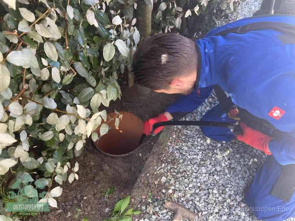 Monteur reinigt een rioolput met een slang, periodieke rioolreiniging in Epe