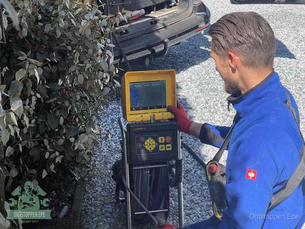 Monteur bedient een rioolinspectiecamera met monitor voor rioolinspectie in Epe