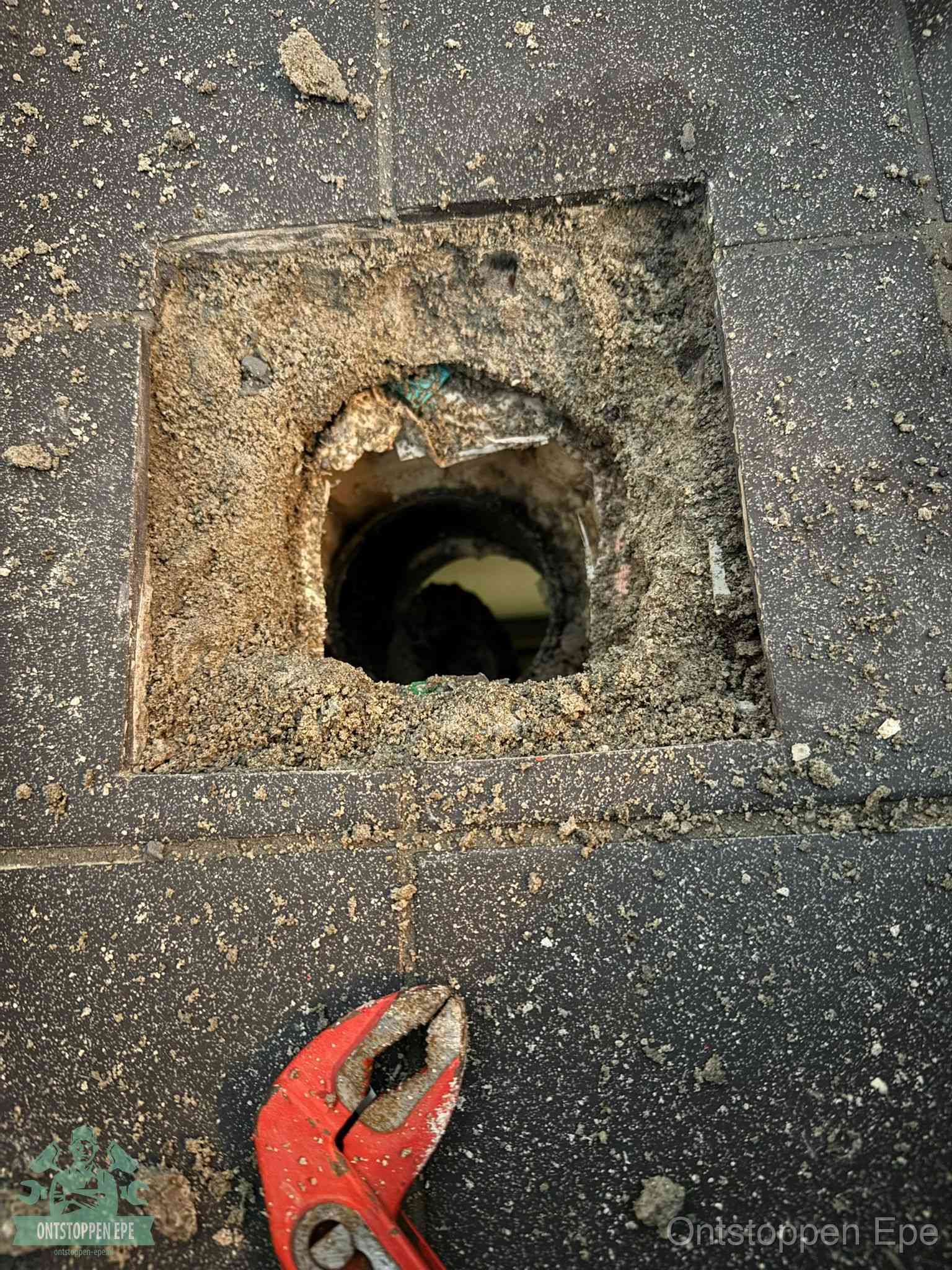 Geopend rioolputje op de erfgrens dat laat zien wie eigenaar is van de riolering in Epe