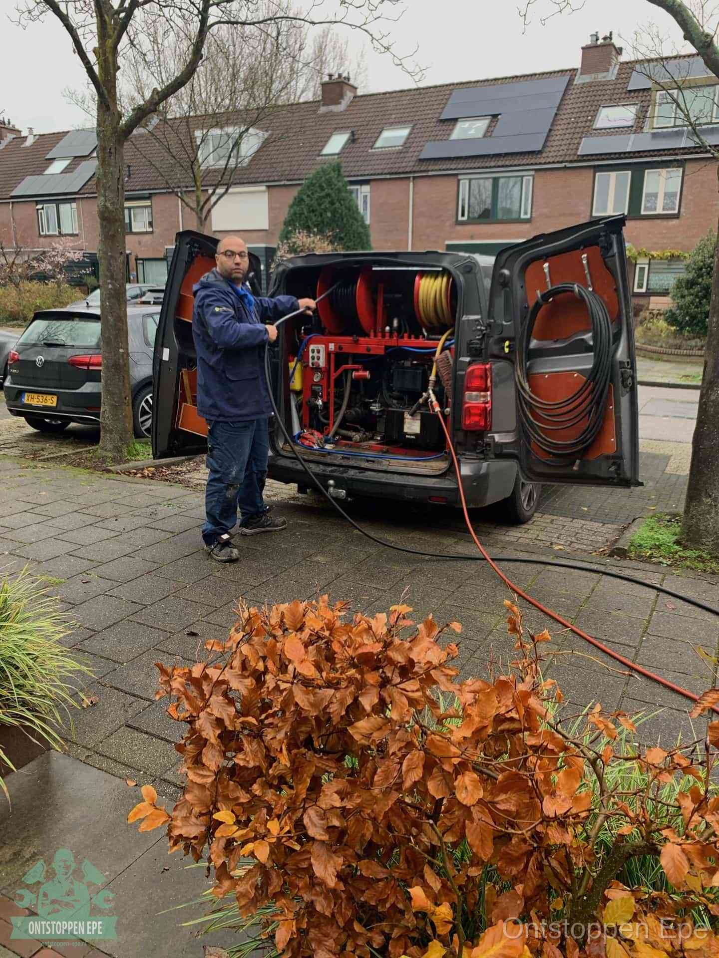 Monteur met rioolreinigingsbus levert rioolservice in de wijk in Epe