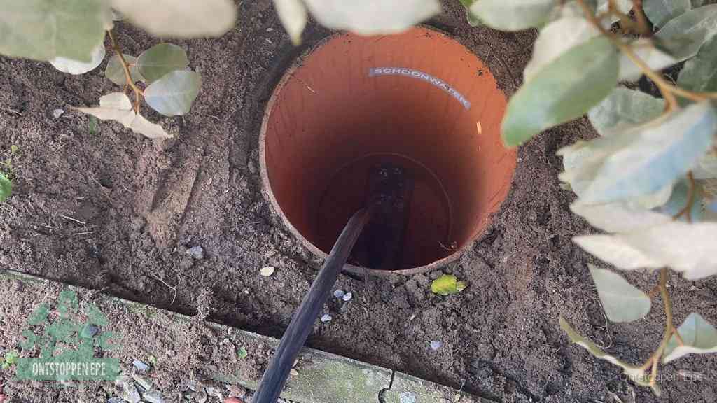 Open inspectieput in de tuin waar een veer rioolvliegjes en stankoverlast aanpakt in Epe