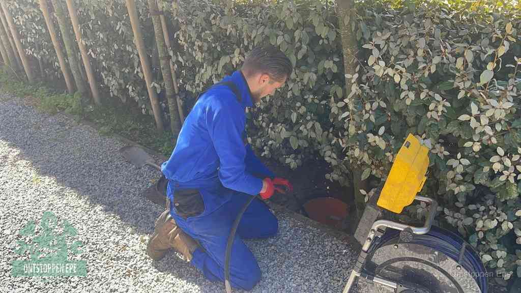 Monteur aan het werk bij een rioolput, de werkwijze voor riool ontstoppen in Epe